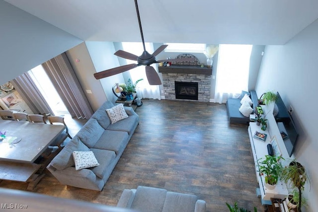 living room with a fireplace, ceiling fan, and wood finished floors