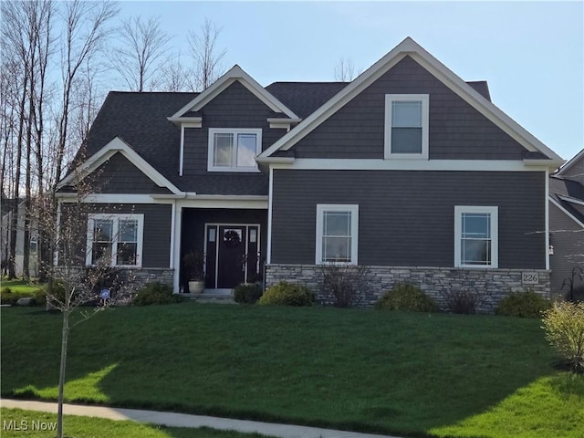 craftsman-style home with stone siding and a front lawn