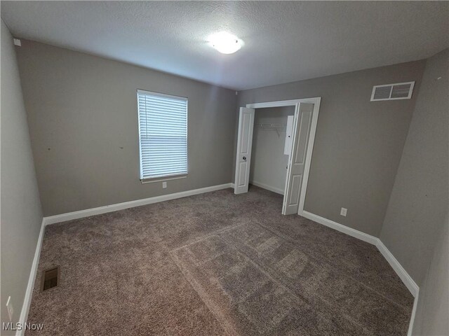226 Hidden Glen Trl, Chardon, OH 44024 - unfurnished bedroom featuring carpet, a textured ceiling, and a closet