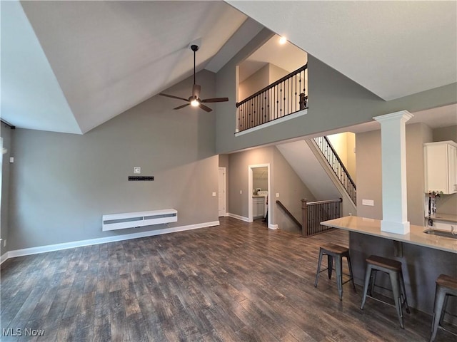 226 Hidden Glen Trl, Chardon, OH 44024 - living area with ceiling fan, dark wood-style floors, decorative columns, stairway, and high vaulted ceiling