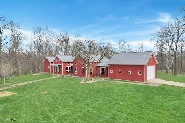 view of front of home featuring concrete driveway, a garage, metal roof, and a front yard