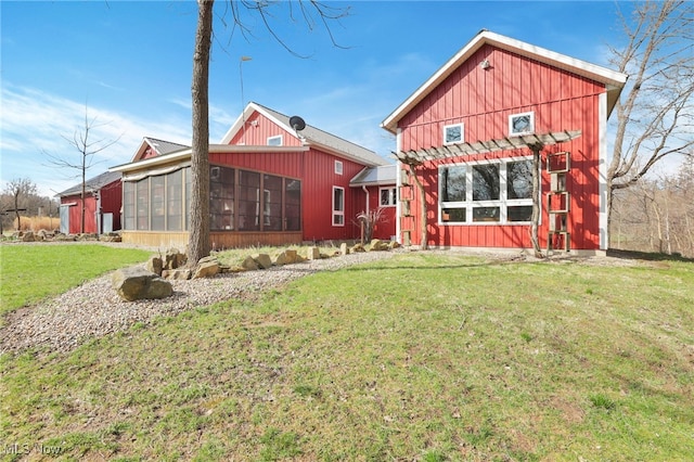 rear view of property featuring a pergola, a sunroom, and a yard