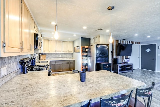 kitchen featuring backsplash, light countertops, appliances with stainless steel finishes, and visible vents