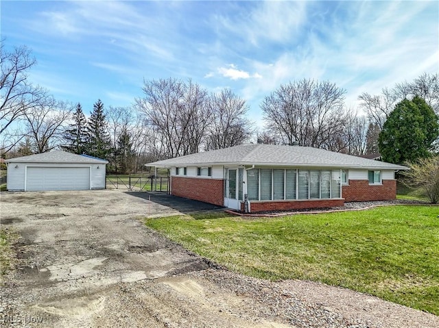 view of home's exterior with a lawn, an outbuilding, a garage, and brick siding