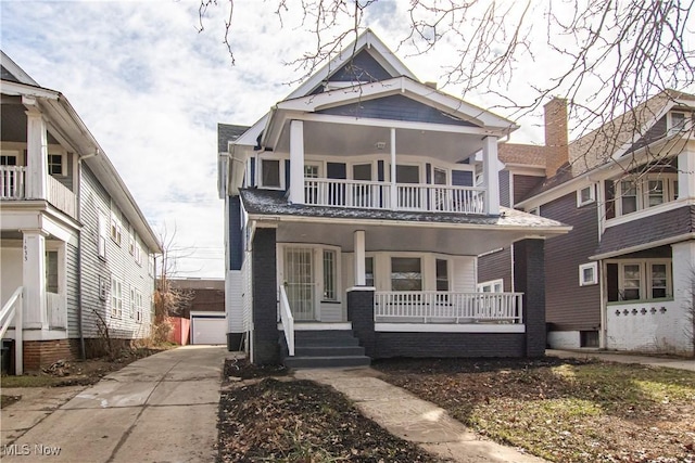 view of front of house featuring a balcony, covered porch, a detached garage, and an outdoor structure