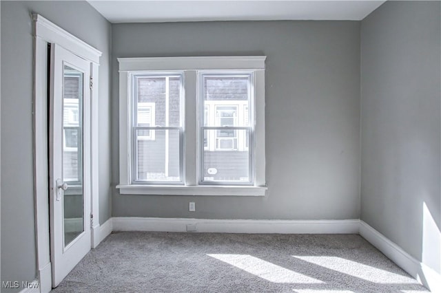 carpeted spare room featuring baseboards