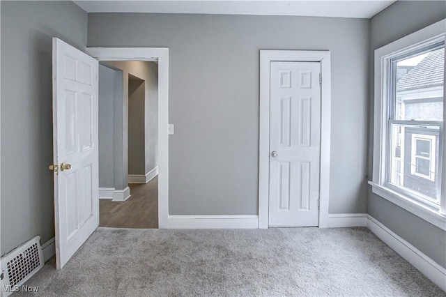 unfurnished bedroom featuring baseboards, visible vents, and carpet