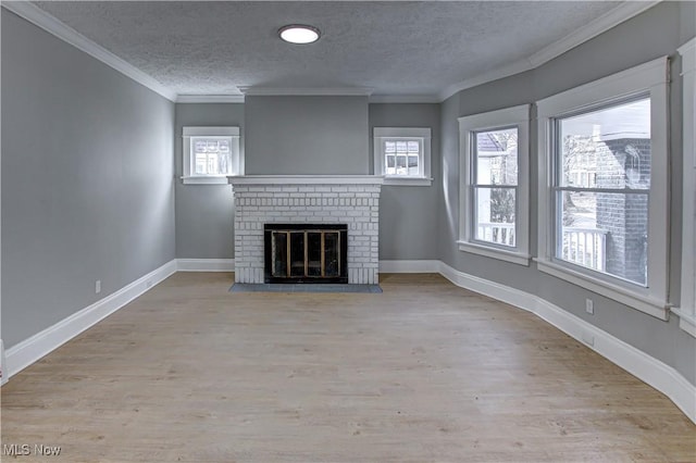 unfurnished living room featuring wood finished floors, ornamental molding, and a brick fireplace
