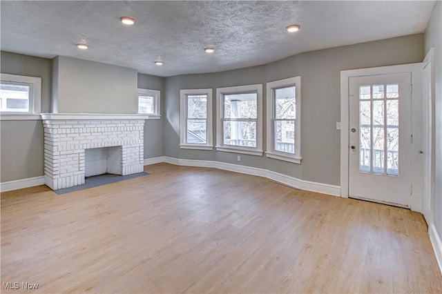 foyer featuring a textured ceiling, baseboards, and wood finished floors