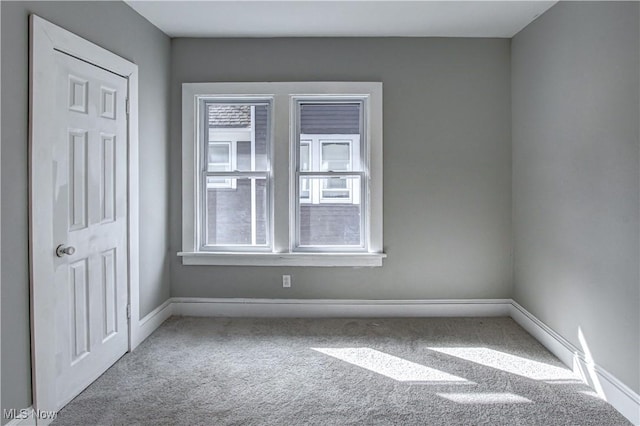 carpeted empty room with baseboards