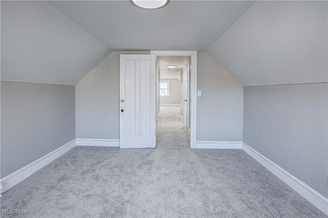 additional living space featuring baseboards, carpet floors, and lofted ceiling