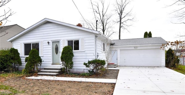 210 Magnolia Ave, Northfield, OH 44067 - bungalow-style house featuring a chimney, concrete driveway, an attached garage, and entry steps