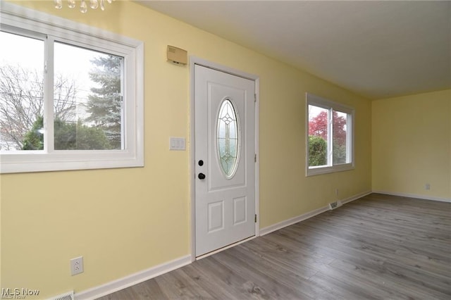 210 Magnolia Ave, Northfield, OH 44067 - foyer with baseboards, visible vents, wood finished floors, and a notable chandelier
