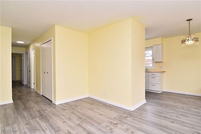 210 Magnolia Ave, Northfield, OH 44067 - spare room with light wood finished floors, baseboards, and an inviting chandelier