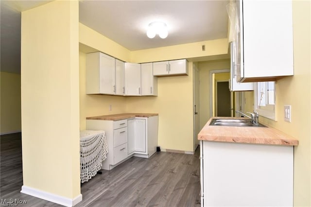 210 Magnolia Ave, Northfield, OH 44067 - kitchen featuring light countertops, baseboards, wood finished floors, white cabinetry, and a sink