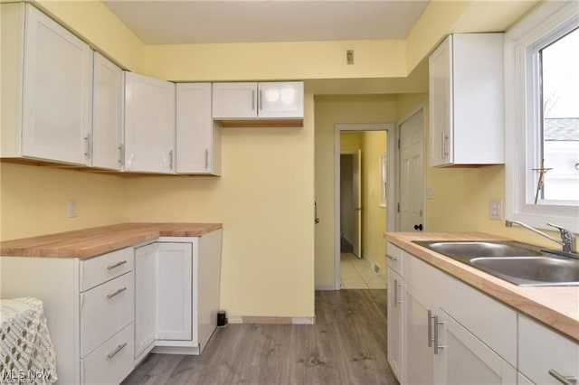 210 Magnolia Ave, Northfield, OH 44067 - kitchen featuring white cabinetry, light countertops, a sink, and wood finished floors
