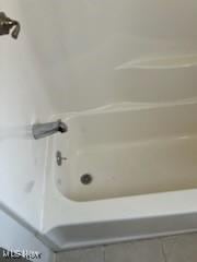 bathroom with a bath and tile patterned floors