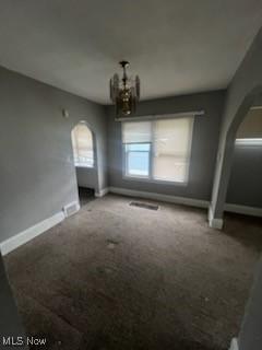 952 Whitby Rd, Cleveland Heights, OH 44112 - unfurnished dining area featuring arched walkways, carpet flooring, baseboards, and an inviting chandelier