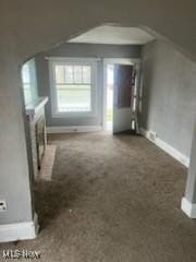 952 Whitby Rd, Cleveland Heights, OH 44112 - unfurnished living room with carpet flooring, arched walkways, and baseboards