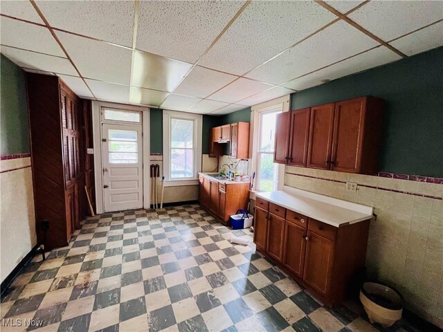 406 Grant St, Newell, WV 26050 - kitchen featuring a paneled ceiling, light countertops, light flooring, a wainscoted wall, and a sink