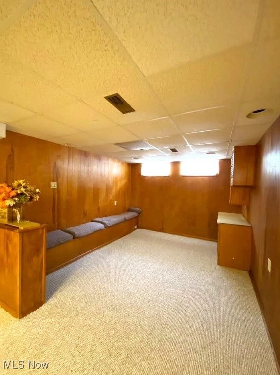 15613 Maplewood Ave, Maple Heights, OH 44137 - basement with wood walls, carpet flooring, and a drop ceiling