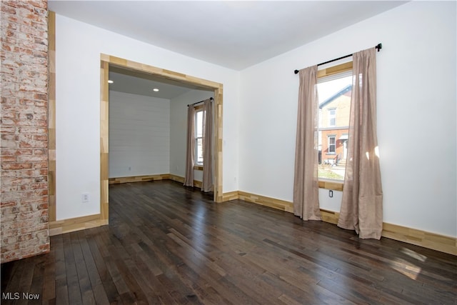 unfurnished room with dark wood finished floors and baseboards