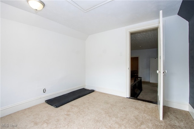 empty room with carpet floors, baseboards, and lofted ceiling