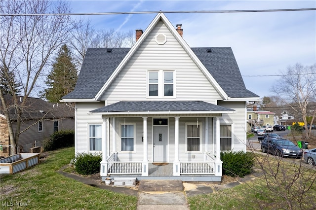 view of front facade with a chimney, a porch, and roof with shingles