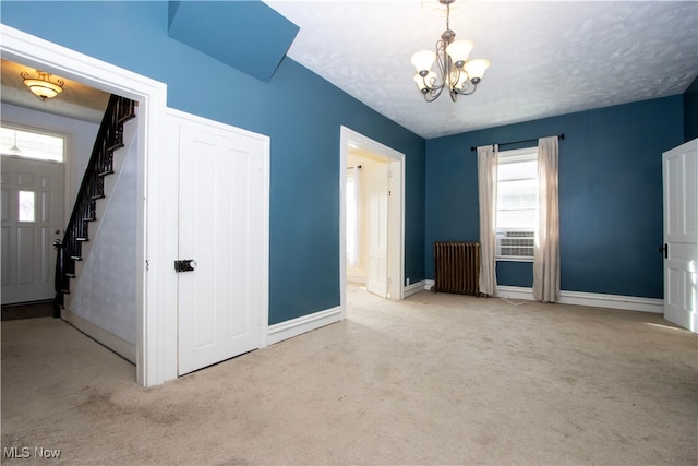 interior space with an inviting chandelier, radiator, carpet, and stairway