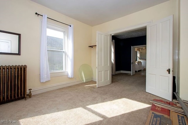 bedroom with baseboards, carpet flooring, and radiator heating unit