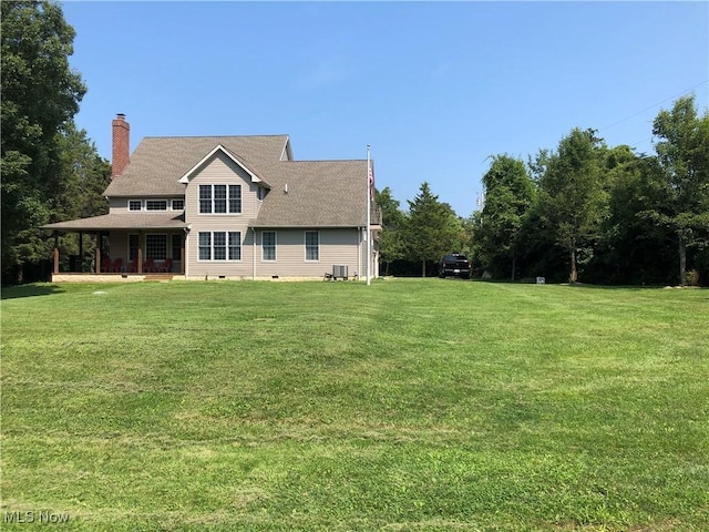 115 Beech St, Kelleys Island, OH 43438 - rear view of house featuring a lawn, central AC, a chimney, and a porch