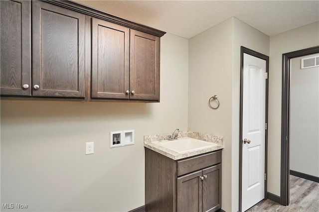 5058 Catawba Place Ln, Seville, OH 44273 - clothes washing area featuring a sink, visible vents, light wood-style floors, cabinet space, and hookup for a washing machine