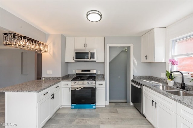 13222 Courtland Ave, Cleveland, OH 44111 - kitchen with a sink, stainless steel appliances, a peninsula, and light stone counters