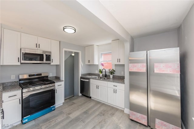 13222 Courtland Ave, Cleveland, OH 44111 - kitchen featuring light wood finished floors, light stone countertops, appliances with stainless steel finishes, white cabinetry, and a sink