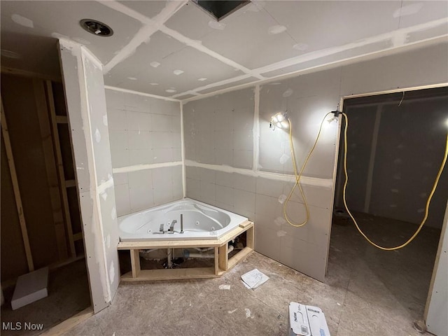 bathroom with a tub with jets
