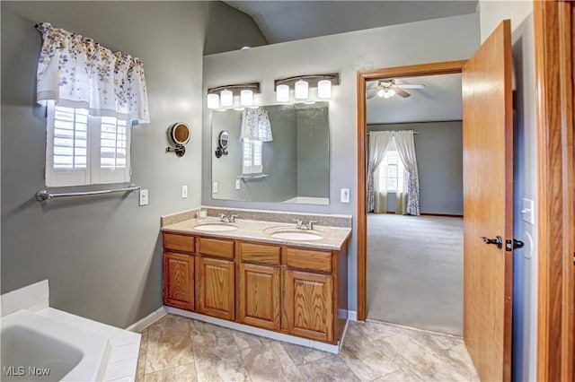 bathroom featuring double vanity, a ceiling fan, a tub, and a sink