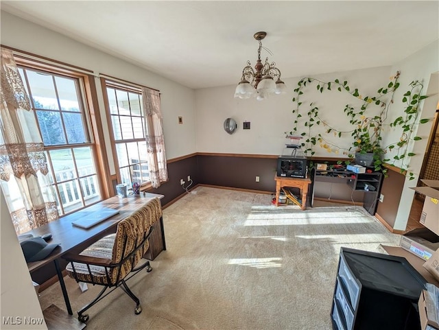 dining space featuring baseboards, carpet floors, and a notable chandelier