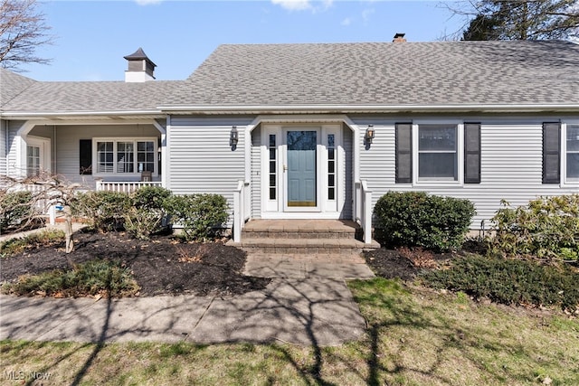 1122 Lake Rd, Conneaut, OH 44030 - view of front facade featuring a porch, roof with shingles, and a chimney