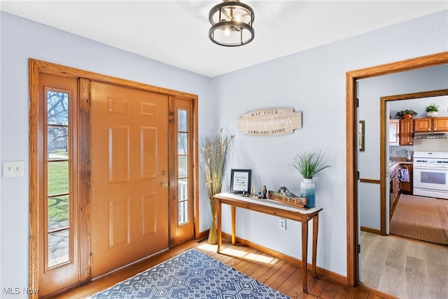 1122 Lake Rd, Conneaut, OH 44030 - foyer entrance featuring an inviting chandelier, baseboards, and light wood finished floors