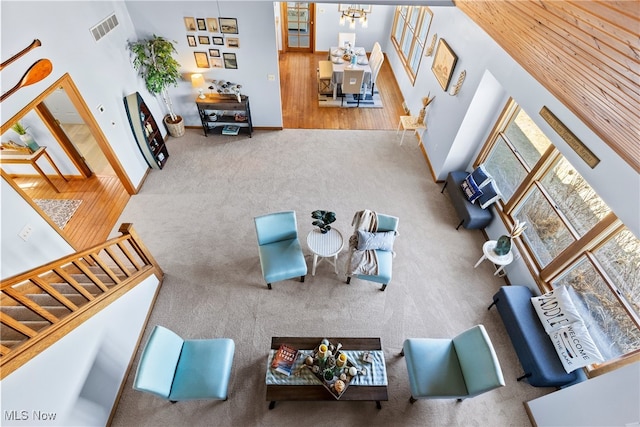 1122 Lake Rd, Conneaut, OH 44030 - living area featuring stairway, baseboards, a chandelier, a towering ceiling, and visible vents