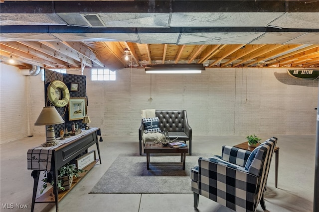 1122 Lake Rd, Conneaut, OH 44030 - living area with brick wall, visible vents, and concrete flooring