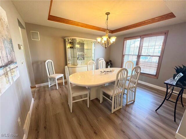 33 Mallards Xing, Canfield, OH 44406 - dining room with a tray ceiling, baseboards, a chandelier, and wood finished floors