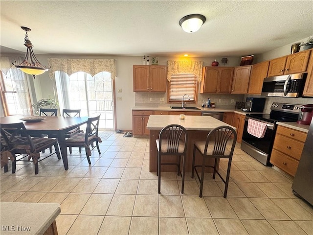 33 Mallards Xing, Canfield, OH 44406 - kitchen featuring decorative backsplash, light countertops, stainless steel appliances, a sink, and light tile patterned floors