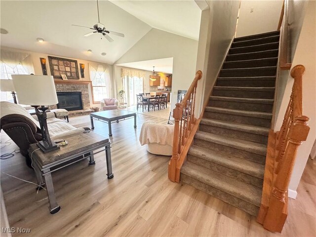 33 Mallards Xing, Canfield, OH 44406 - living room featuring stairway, high vaulted ceiling, light wood-style floors, a ceiling fan, and a fireplace