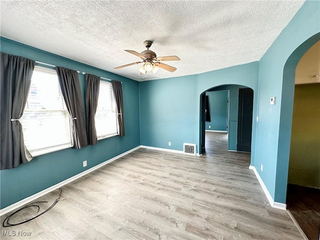 87R 26th St, Wellsburg, WV 26070 - spare room with a ceiling fan, wood finished floors, arched walkways, and visible vents