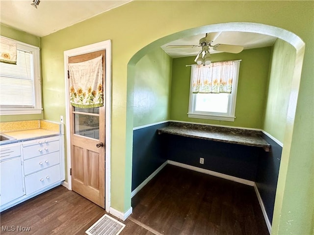 87R 26th St, Wellsburg, WV 26070 - kitchen with white cabinetry, baseboards, arched walkways, ceiling fan, and dark wood-style flooring