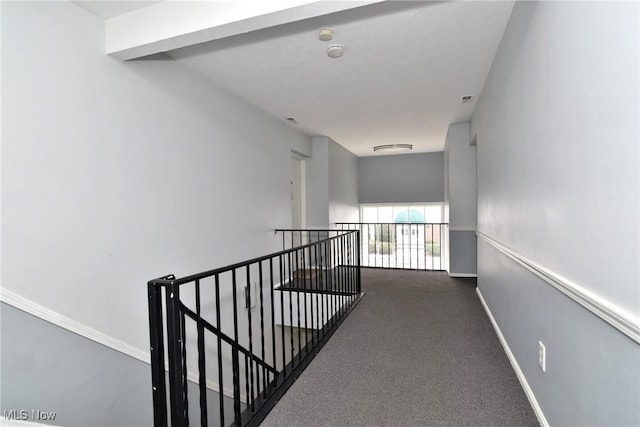 hall with an upstairs landing, carpet, and baseboards