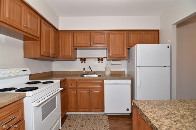 kitchen with a sink, brown cabinets, and white appliances