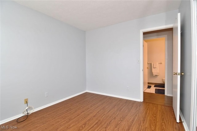 unfurnished room featuring baseboards and wood finished floors