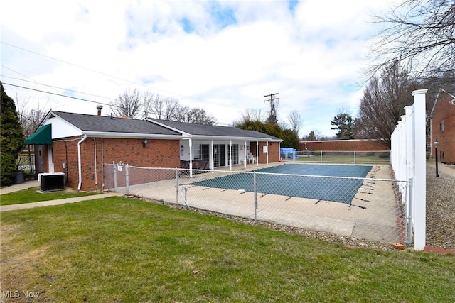 view of pool with a tennis court, central AC, fence, and a lawn
